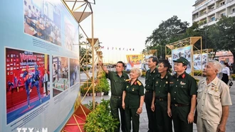 Các cựu chiến binh tham quan triển lãm. Ảnh: Thu Hương/TTXVN.