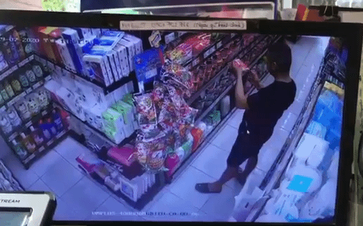 Người đàn ông nhổ, bôi nước bọt lên hàng hóa ở siêu thị mini tại Đà Nẵng. Ảnh cắt từ clip.