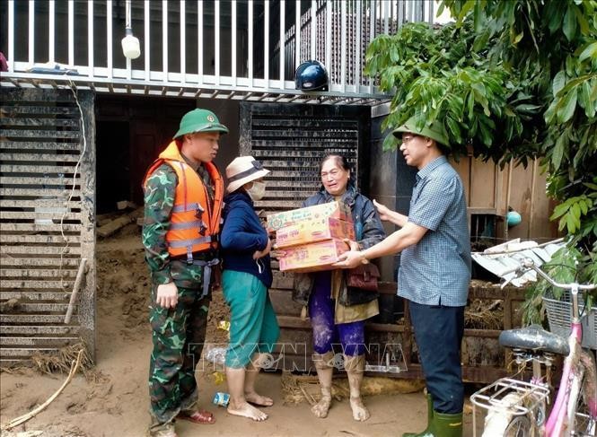Lãnh đạo huyện Kỳ Sơn (Nghệ An) trao nhu yếu phẩm cho người dân thị trấn Mường Xén bị thiệt hại nặng sau lũ quét. Ảnh: Tá Chuyên/TTXVN