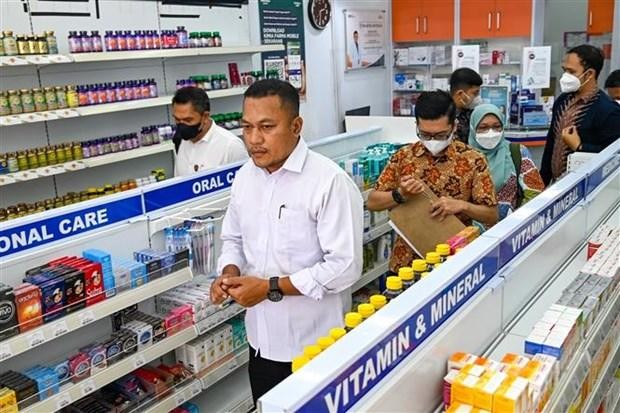 Cảnh sát và nhân viên y tế kiểm tra thuốc siro ho tại một cửa hàng thuốc ở Banda Aceh (Indonesia), ngày 24/10/2022. (Ảnh: AFP)