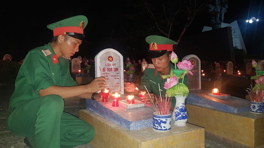 Các đoàn viên thanh niên thắp nến, dâng hương tại mộ các liệt sĩ. Ảnh: VGP