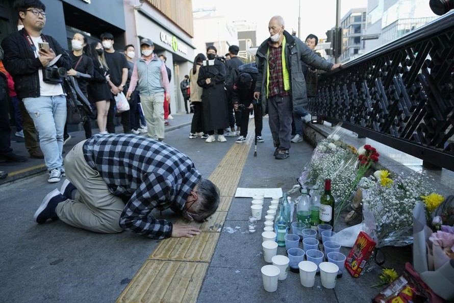 Một người đàn ông lớn tuổi vái lạy tại khu tưởng niệm do người dân Seoul tự lập gần hiện trường vụ giẫm đạp. Ảnh: AP