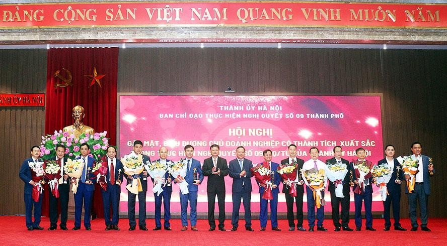 Phó Bí thư Thành ủy Hà Nội Nguyễn Văn Phong và Trưởng ban Tổ chức Thành ủy Hà Nội Vũ Đức Bảo trao hoa và biểu trưng cho các chủ doanh nghiệp có thành tích xuất sắc trong thực hiện Nghị quyết số 09-NQ/TU.
