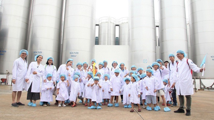 Các bé chụp ảnh cùng bố mẹ tại khu vực bồn chứa sữa tươi khổng lồ của nhà máy.