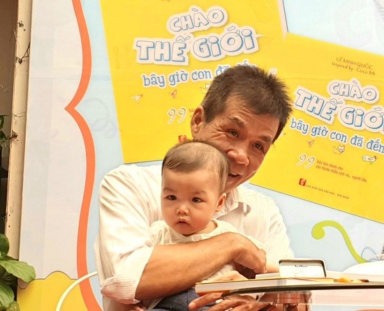 Nhà thơ Lê Minh Quốc và con gái nhỏ trong buổi ra mắt sách Chào thế giới bây giờ con đã đến. Ảnh: NXB