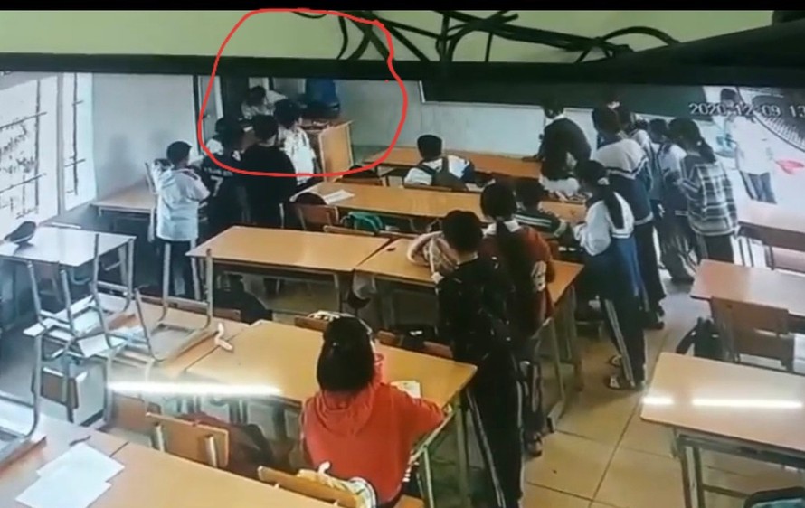 Vị phụ huynh côn đồ (áo xanh) đang tấn công học sinh mặc đồng phục được camera ghi lại. (Ảnh: Giáo dục & Thời đại)