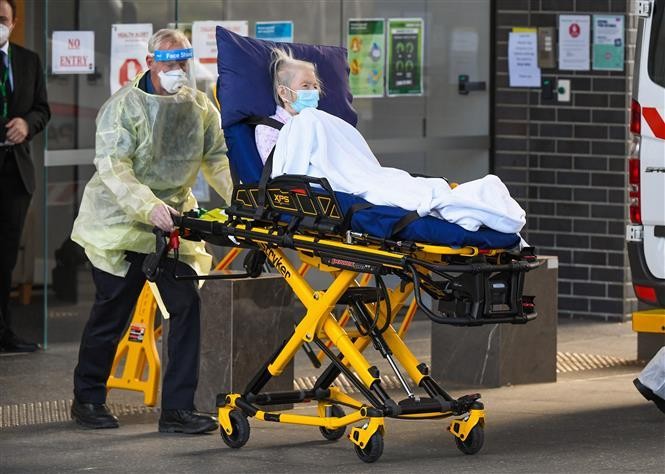 Nhân viên y tế chuyển người già khỏi viện dưỡng lão ở Epping Melbourne, Australia khi dịch COVID-19 bùng phát tại đây. Ảnh: AFP/TTXVN