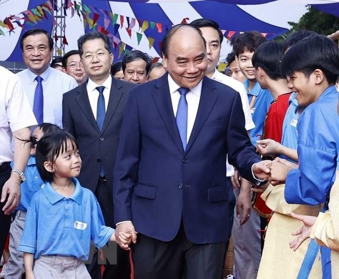 Chủ tịch nước Nguyễn Xuân Phúc với học sinh trường tiểu học, THCS và THPT Hy Vọng. (Ảnh: Thống Nhất/TTXVN) 
