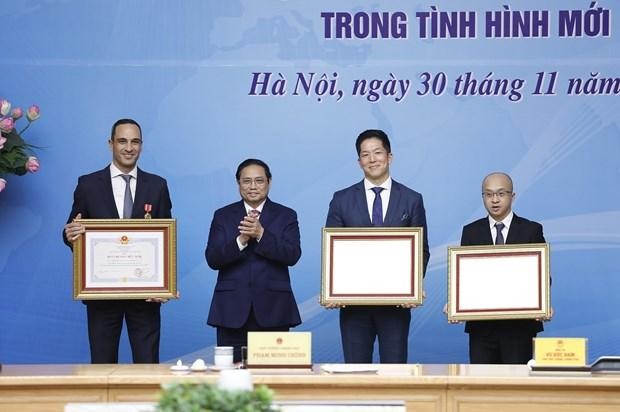 Đại diện Công ty AstraZeneca Việt Nam (phải) nhận bằng khen của Thủ tướng Chính phủ Phạm Minh Chính cho những đóng góp nổi bật về triển khai công tác ngoại giao vaccine của Việt Nam. (Ảnh: Dương Giang/TTXVN)