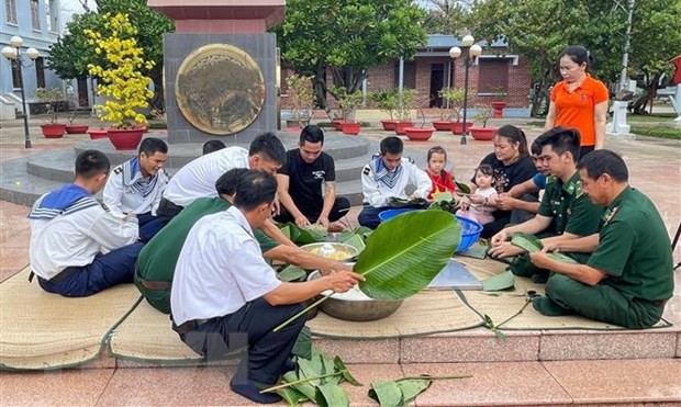 Quân và dân đảo Trường Sa cùng gói bánh chưng đón Tết Quý Mão 2023. (Ảnh: Nguyễn Cúc/TTXVN)