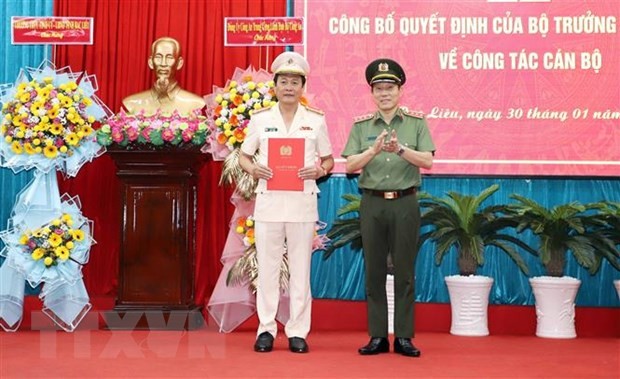 Thứ trưởng Bộ Công an Lương Tam Quang (phải) trao Quyết định và tặng hoa Đại tá Hồ Việt Triều, Giám đốc Công an tỉnh Bạc Liêu. (Ảnh: TTXVN phát)