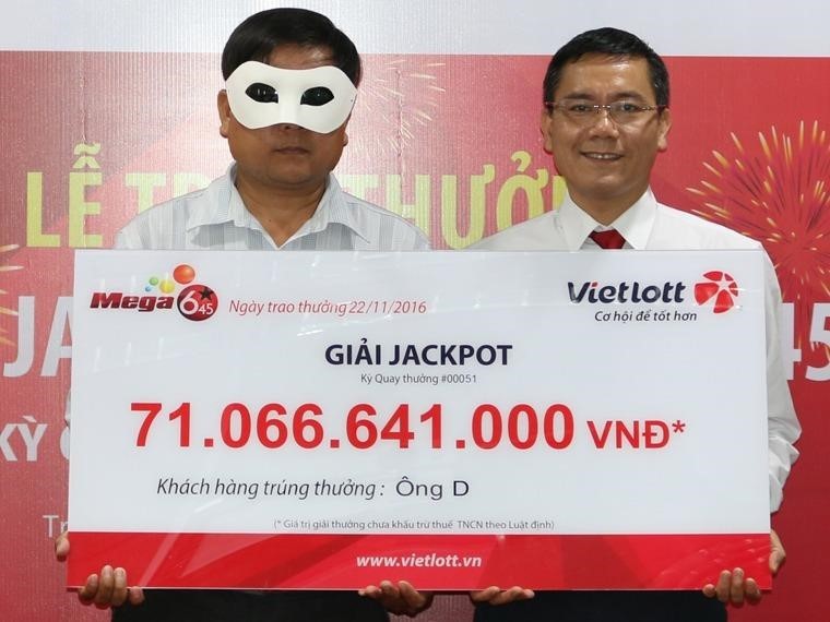Đại diện công ty xổ số điện toán trao thưởng trên 71 tỷ đồng cho người đàn ông quê Quảng Ngãi. Ảnh: Vietlott cung cấp.