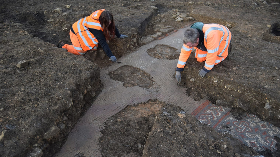 Thành viên của nhóm khảo cổ làm sạch các đường viền của bức tranh khảm. Ảnh: Courtesy Oxford Archaeology