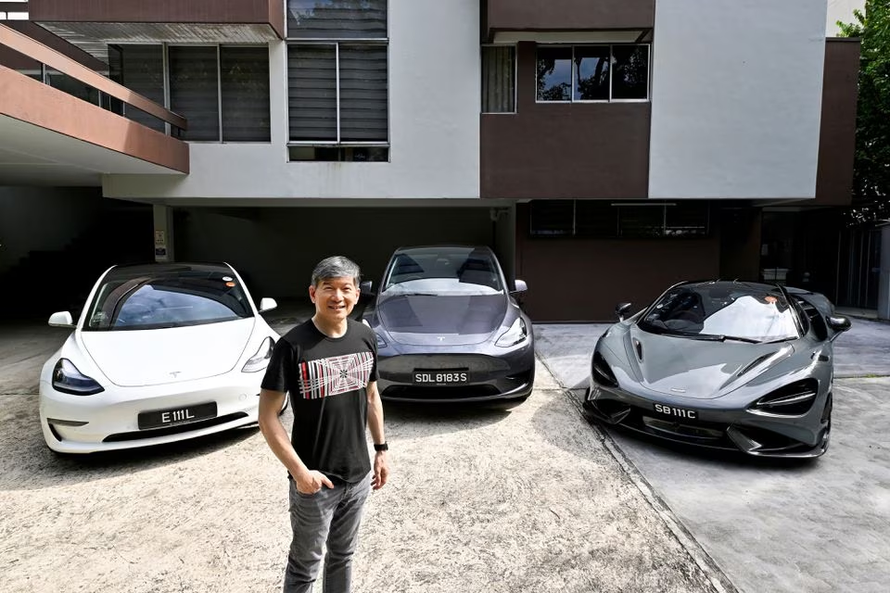 Eu Gene Goh chụp ảnh với ba chiếc ô tô của mình, Tesla Model 3, Tesla Model Y và McLaren 765LT. Ảnh: Reuters