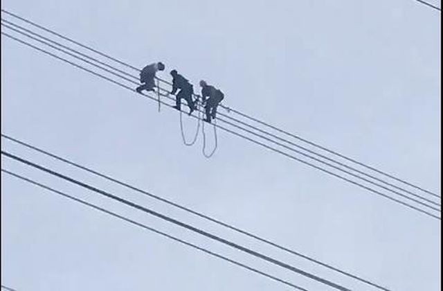 Lực lượng chức năng giải cứu nam thanh niên ngồi trên đường dây điện cao thế.