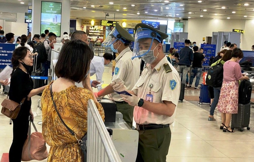 Nhân viên an ninh hàng không kiểm tra giấy tờ hành khách đi máy bay. 