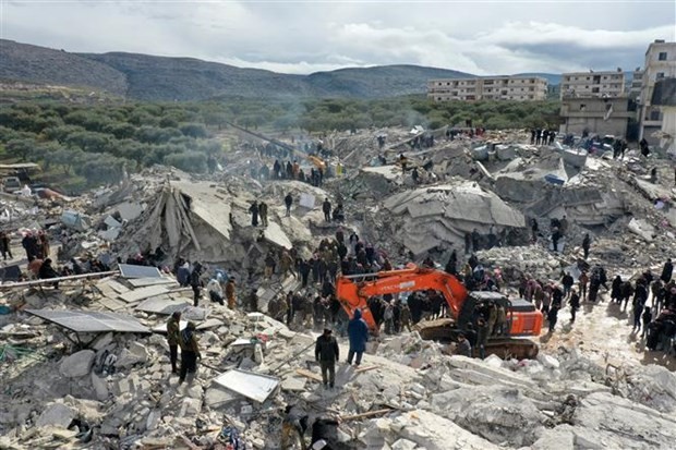 Lực lượng cứu hộ và tình nguyện viên tìm kiếm các nạn nhân và người sống sót mắc kẹt trong đống đổ nát sau động đất mạnh ở làng Besnia, gần thị trấn Harim, tỉnh Idlib (Syria), giáp giới Thổ Nhĩ Kỳ. (Ảnh: AFP)