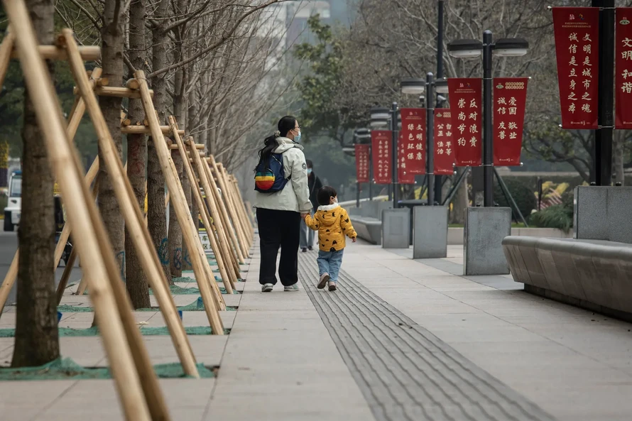 Một người mẹ dắt con đi dạo tại thành phố Thượng Hải, Trung Quốc.
