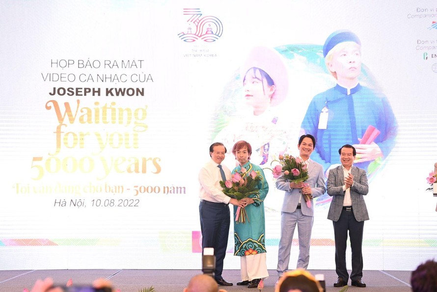 Thứ trưởng Bộ VHTTDL Tạ Quang Đông và Phó Tổng cục trưởng Hà Văn Siêu tặng hoa cho ca sĩ, nhạc sĩ Hàn Quốc Joseph Kwon và đơn vị thực hiện.