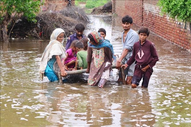 Người dân sơ tán khỏi vùng ngập lụt tại huyện Tando Allahyar, tỉnh Sindh, Pakistan, ngày 25/8/2022. Ảnh: TTXVN