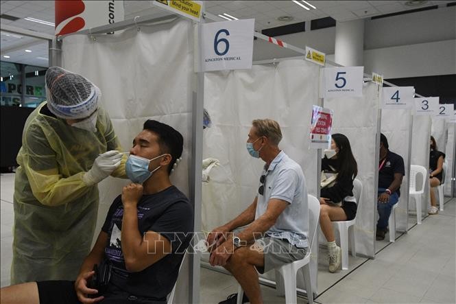 Nhân viên y tế lấy mẫu xét nghiệm COVID-19 cho người dân tại Singapore. Ảnh tư liệu: TTXVN