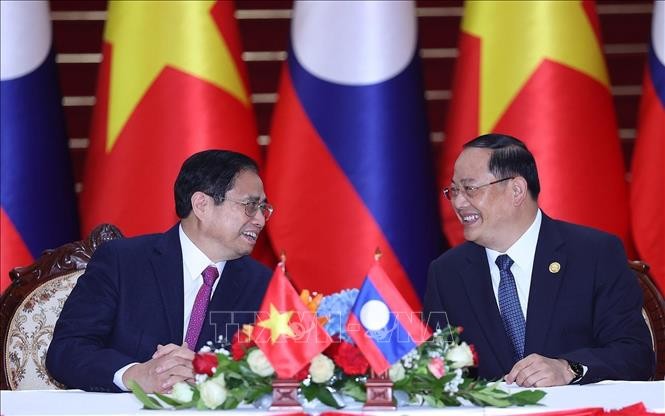 Thủ tướng Phạm Minh Chính và Thủ tướng Lào Sonexay Siphandone trao đổi tại lễ ký các văn kiện hợp tác giữa hai nước Việt Nam - Lào. Ảnh: Dương Giang