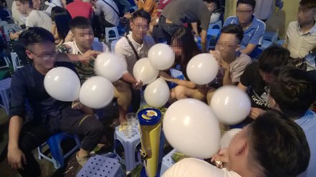 Một nhóm bạn trẻ cùng sử dụng bóng cười tại khu phố Tạ Hiện, Hà Nội.