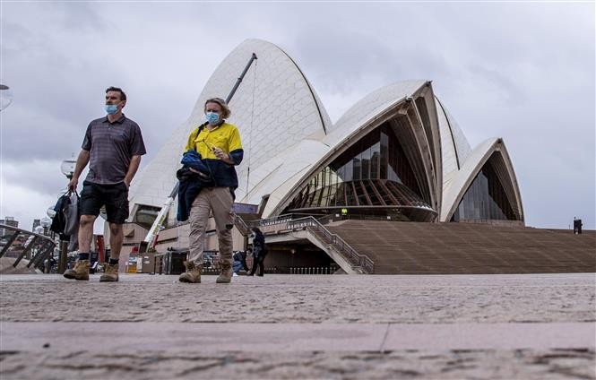 Người dân đi bộ tại khu vực Nhà hát Opera ở thành phố Sydney, Australia ngày 11/10/2021. Ảnh: THX/TTXVN
