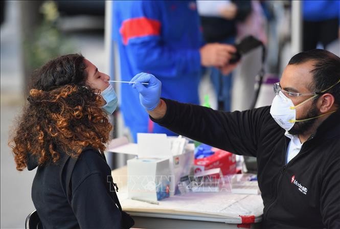 Nhân viên y tế lấy mẫu xét nghiệm COVID-19 cho người dân tại New York, Mỹ. Ảnh: AFP/TTXVN