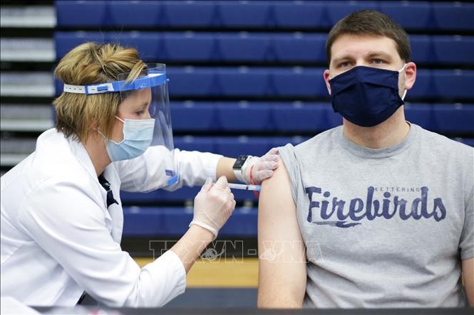 Nhân viên y tế tiêm vaccine ngừa COVID-19 cho giáo viên tại một trường học ở Dayton, Ohio, Mỹ. Ảnh: AFP/TTXVN
