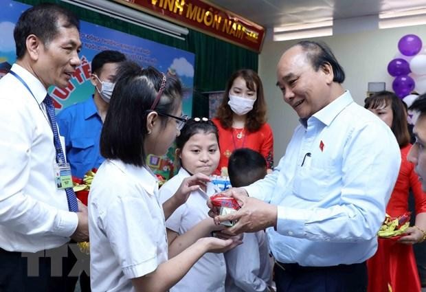 Chủ tịch nước Nguyễn Xuân Phúc tặng quà cho trẻ khuyết tật. (Ảnh An Đăng/TTXVN)