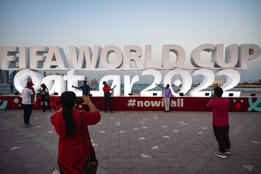 Du khách chụp ảnh trước biểu tượng World Cup tại Doha. Ảnh: AFP