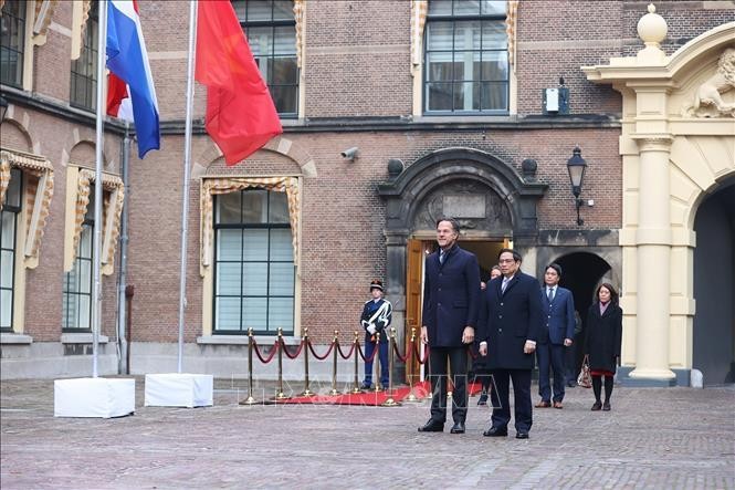 Thủ tướng Phạm Minh Chính và Thủ tướng Hà Lan Mark Rutte nghe quân nhạc cử quốc thiều hai nước. Ảnh: Dương Giang/TTXVN