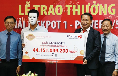 Khách hàng đeo mặt nạ che mặt khi nhận giải thưởng hơn 44 tỷ đồng. Ảnh: Xuân Ngọc