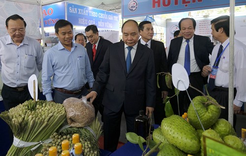 Thủ tướng thăm các gian hàng trưng bày sản phẩm của các DN đang đầu tư tại Tiền Giang. Ảnh: VGP/Quang Hiếu