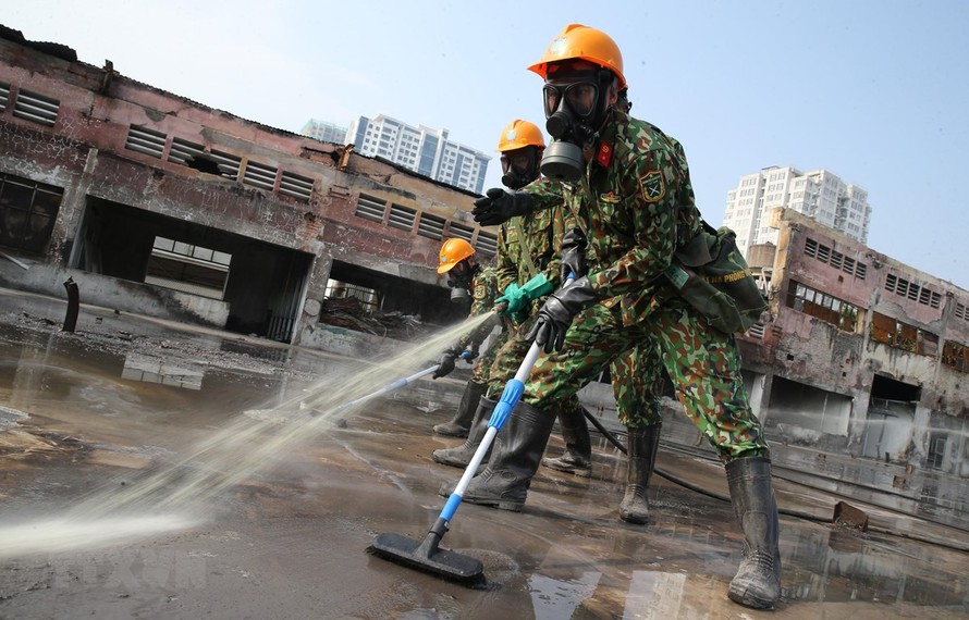 Lực lượng Binh chủng Hoá học phun hóa chất tẩy độc mặt nền nhà xưởng của Công ty Rạng Đông, ngày 5/10. (Ảnh: Dương Giang/TTXVN)