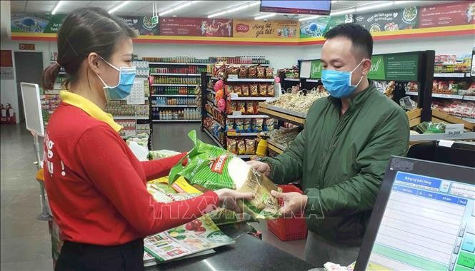 Người dân chủ động phòng, chống dịch COVID-19 bằng cách đeo khẩu trang khi đi chợ, siêu thị. Ảnh: TTXVN