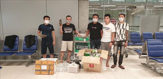 Nhóm công dân Việt Nam bị mắc kẹt tại sân bay Survanabhumi tiếp nhận thức ăn và đồ dùng thiết yếu do cán bộ Đại sứ quán chuyển đến. Ảnh: TTXVN phát