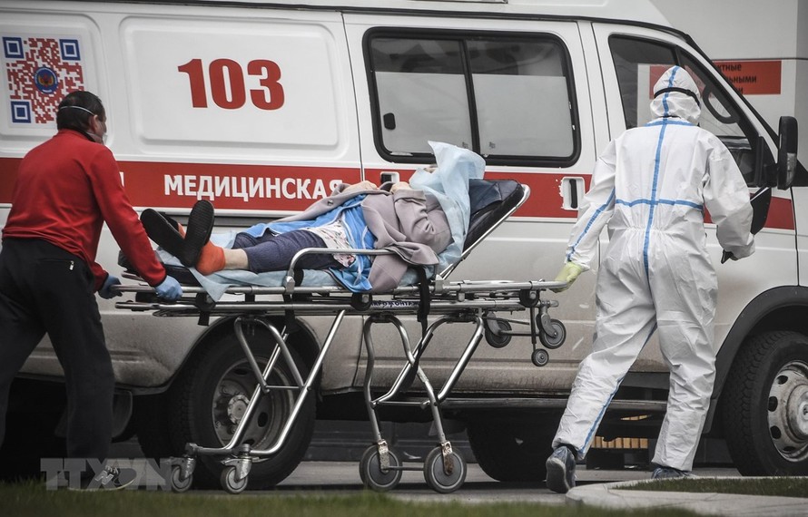 Nhân viên y tế chuyển bệnh nhân nhiễm COVID-19 tới bệnh viện ở Moskva, Nga. (Ảnh: AFP/TTXVN)