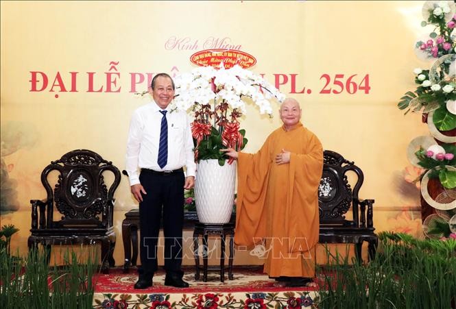 Ủy viên Bộ Chính trị, Phó Thủ tướng Thường trực Chính phủ Trương Hòa Bình (trái) tặng hoa chúc mừng Hòa thượng Thích Thiện Nhơn, Chủ tịch Hội đồng Trị sự, Giáo hội Phật giáo Việt Nam (phải) và các tăng ni, phật tử nhân Đại lễ Phật đản.