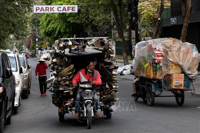  Người bán hàng rong trên một đường phố ở Phnom Penh, Campuchia, ngày 24/3/2020. Ảnh: AFP/TTXVN