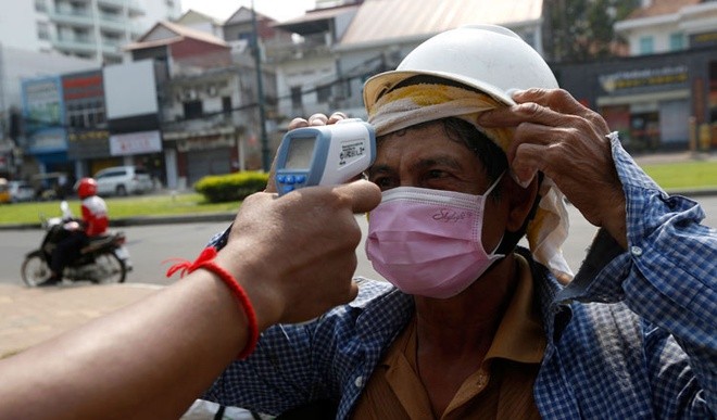 Một người dân đang đo nhiệt độ cơ thể. Ảnh: Khmer Times.