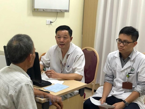 Phó giáo sư Đỗ Trường Thành khám cho một bệnh nhân. (Ảnh: PV/Vietnam+)