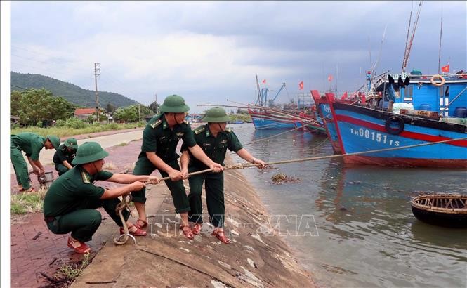 Lực lượng Đồn biên phòng Cửa Sót (Hà Tĩnh) giúp ngư dân giằng néo tàu thuyền phòng chống bão số 4. Ảnh: Công Tường/TTXVN