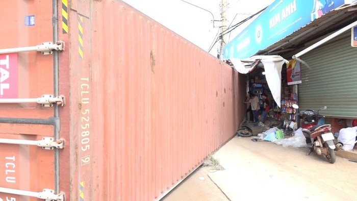 Thùng xe container văng vào quán tạp hóa bên đường (ảnh AX)