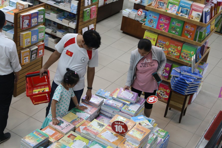Phụ huynh tìm mua sách giáo khoa cho con, tại một cửa hàng sách TP Hồ Chí Minh. Ảnh: NLĐ.