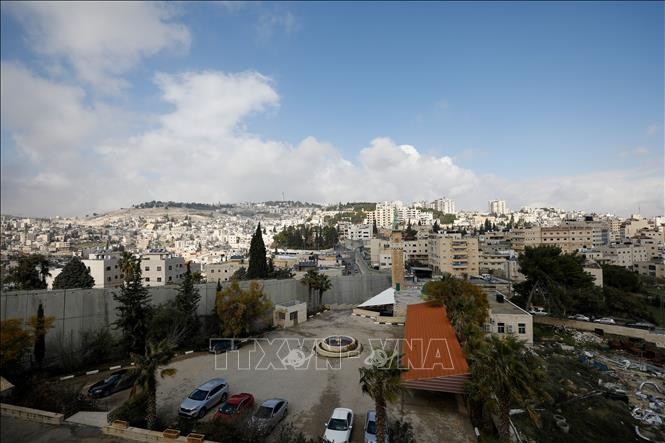 Bức tường ngăn cách khu vực Đông Jerusalem (trái) và ngôi làng Abu Dis của người Palestine. Ảnh: AFP/TTXVN