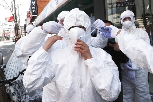 Nhân viên y tế mặc quần áo bảo hộ tại khu vực nguy cơ lây nhiễm cao COVID-19 ở Hàn Quốc. (Nguồn: AP).