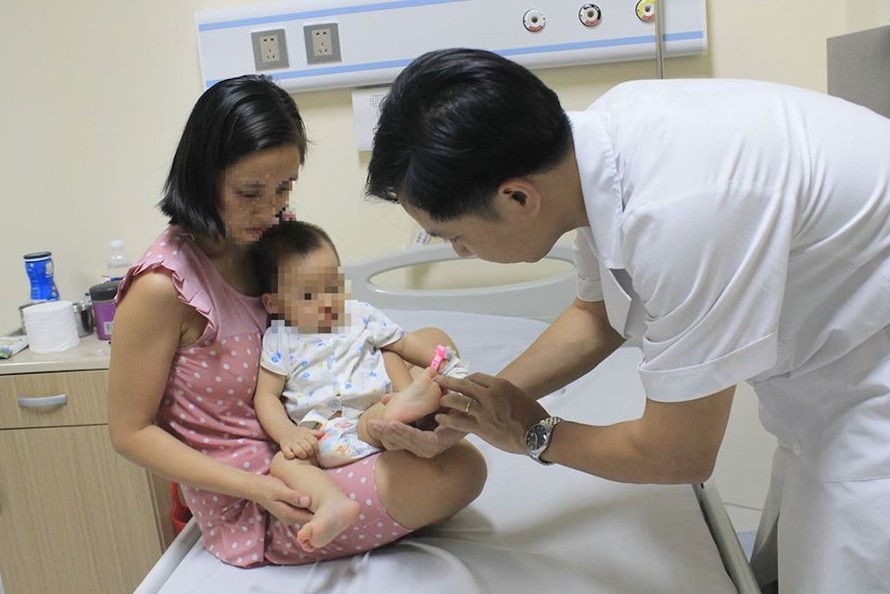 Bác sĩ thăm khám cho trẻ bị tay chân miệng tại Bệnh viện E
