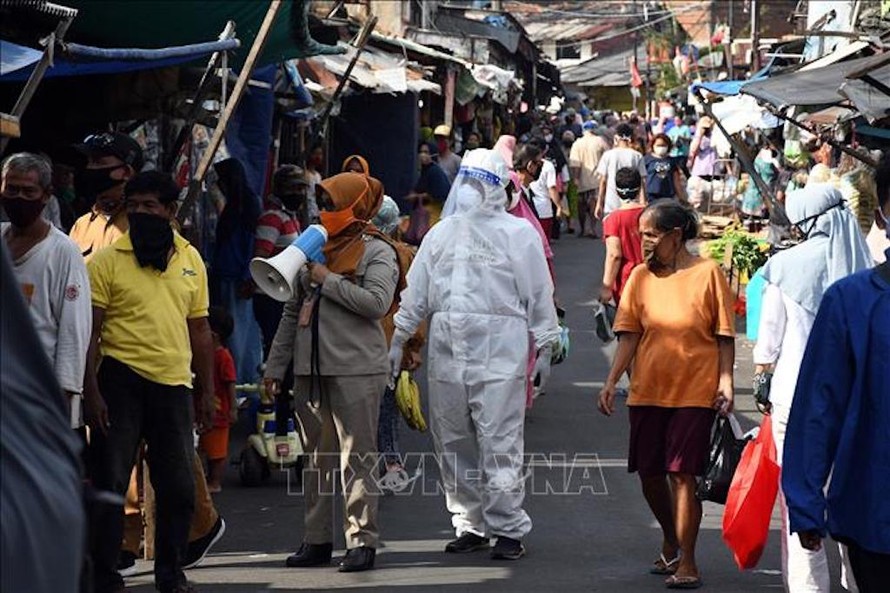 Nhân viên y tế kêu gọi người dân xét nghiệm COVID-19 tại một khu chợ ở Jakarta, Indonesia ngày 2/6/2020. Ảnh minh họa: THX/TTXVN